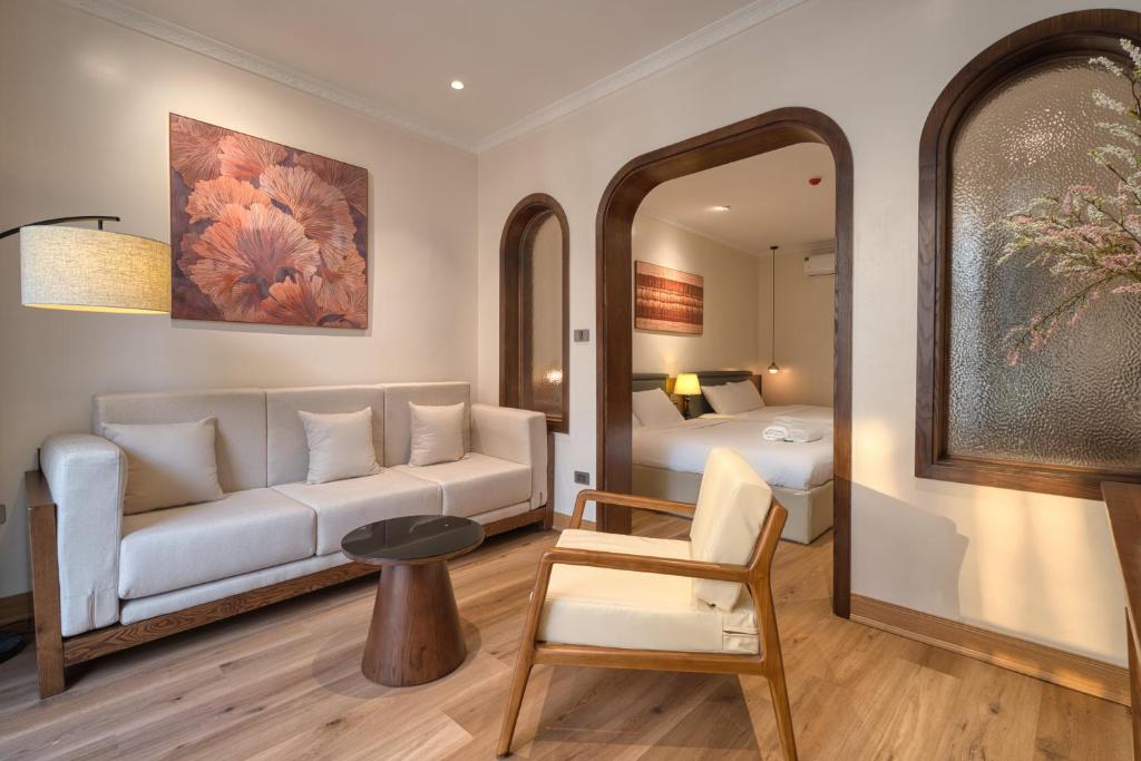 a living room with a couch and a bed and a mirror at Home en Lagom in Hanoi