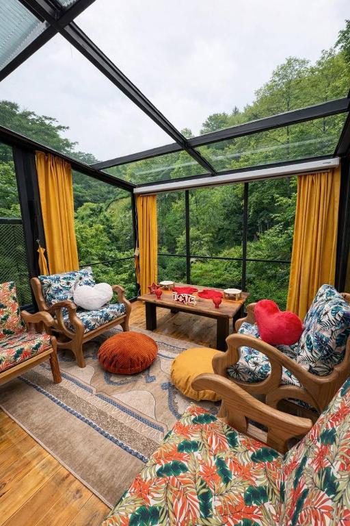 a living room with a view of the forest at Moon River Bungalow in Ayder Yaylasi