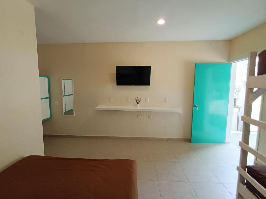 a bedroom with a tv on the wall and a bed at Turquesa Bacalar Centro in Bacalar