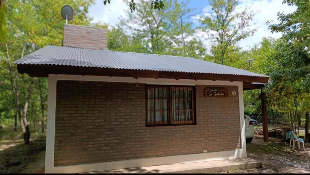 a small brick building with a tin roof at Cabaña la Gabita in Villa Ciudad Parque