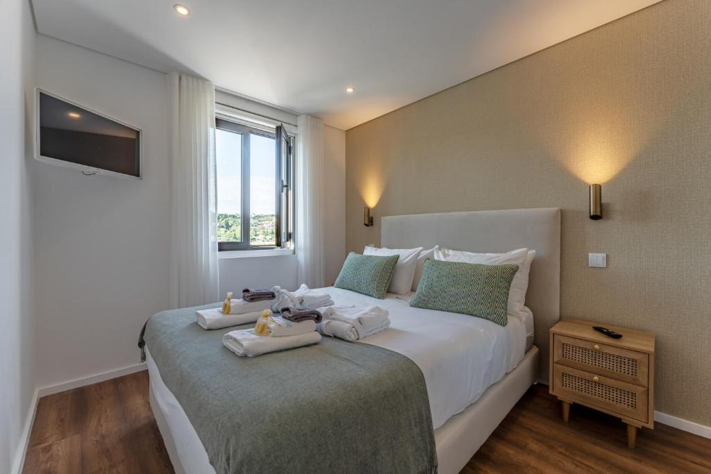 a bedroom with a large bed with towels on it at Douro View Charming Apartment Duplex in Valbom