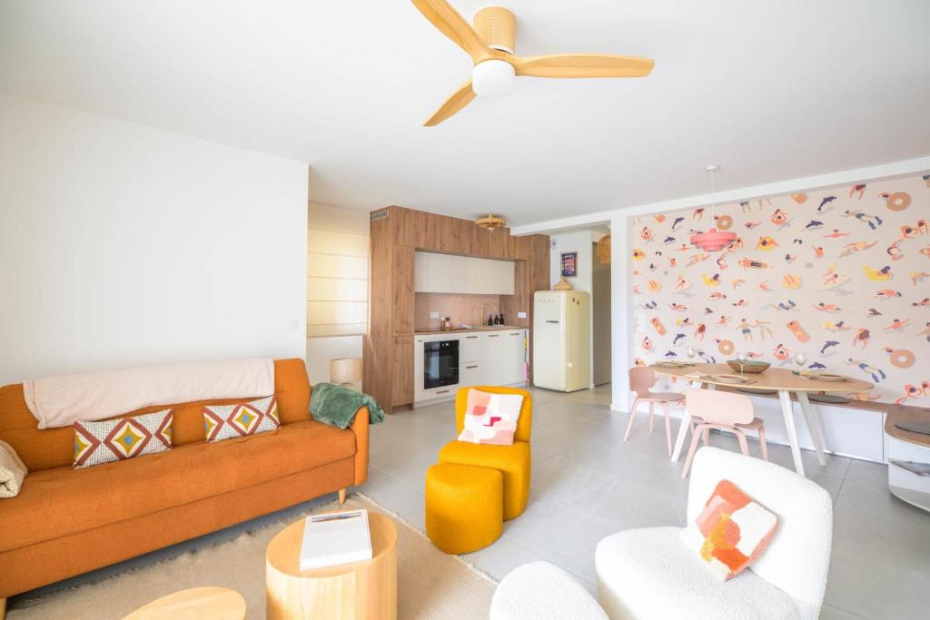 a living room with a couch and a dining room at Bright House between Ocean and Golf in Moliets-et-Maa