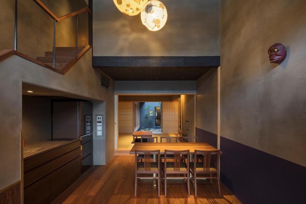 a dining room with a wooden table and chairs at Masarigusa Machiya House in Kyoto