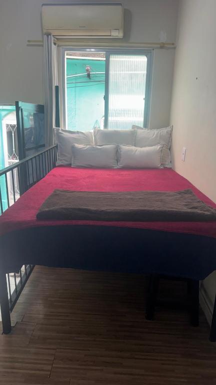 a large bed in a room with a window at Na Ladeira Studio 06 in Rio de Janeiro