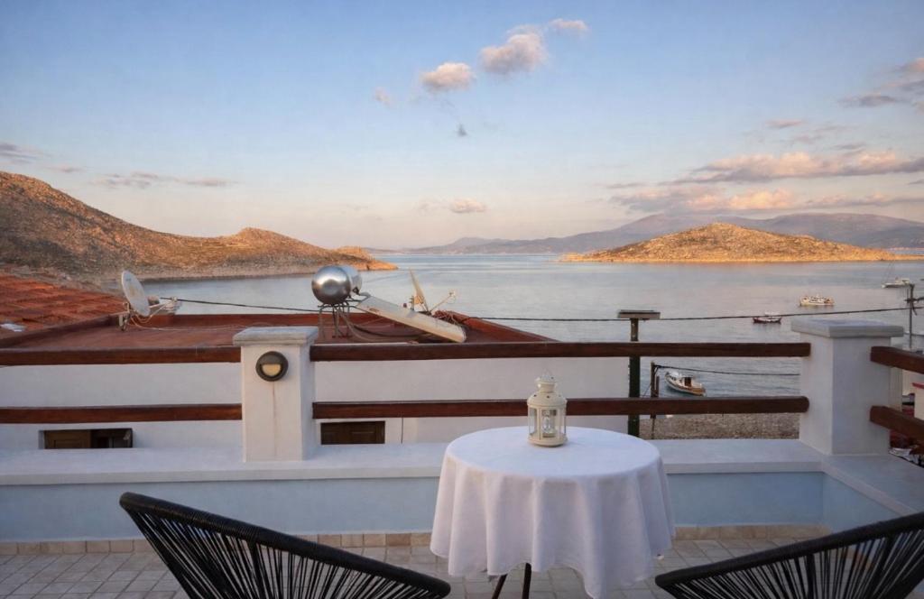 a table and chairs on a balcony with a view of the water at Aegean soul apartments in Halki