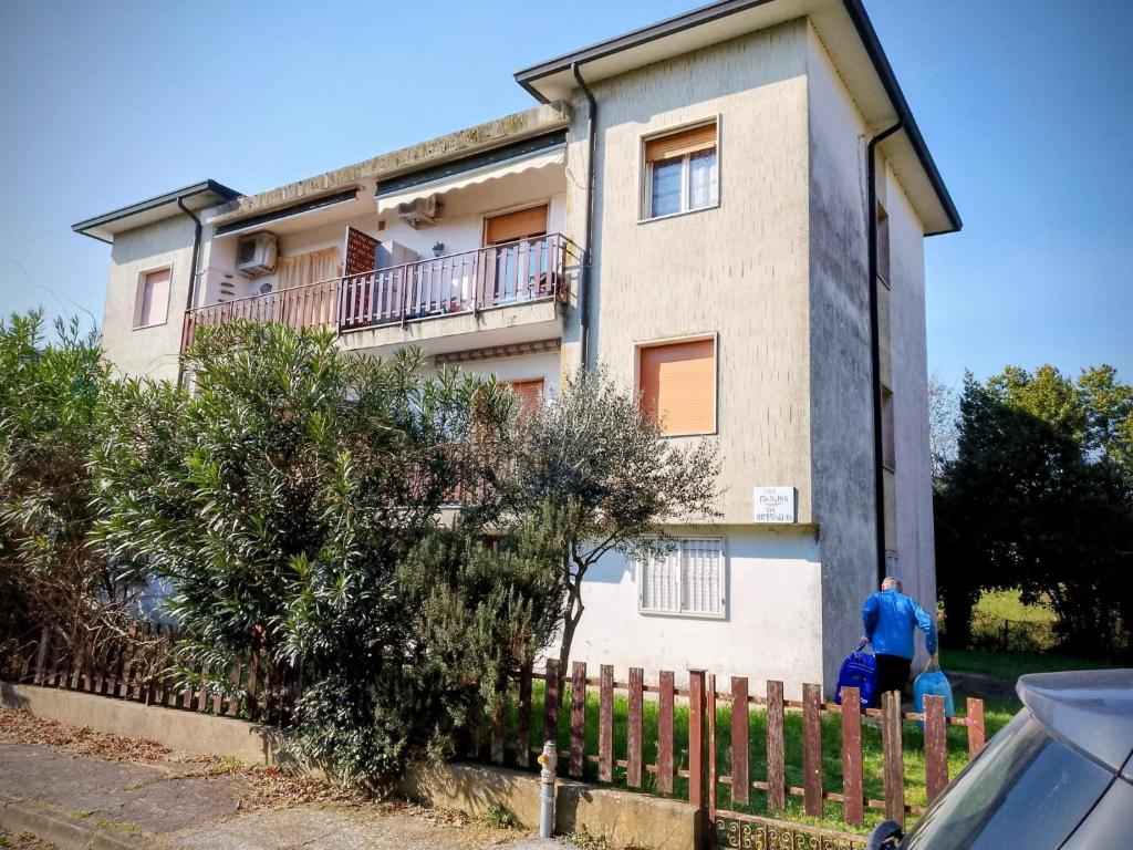 Ein Mann steht vor einem Haus in der Unterkunft Volano in Lido di Volano