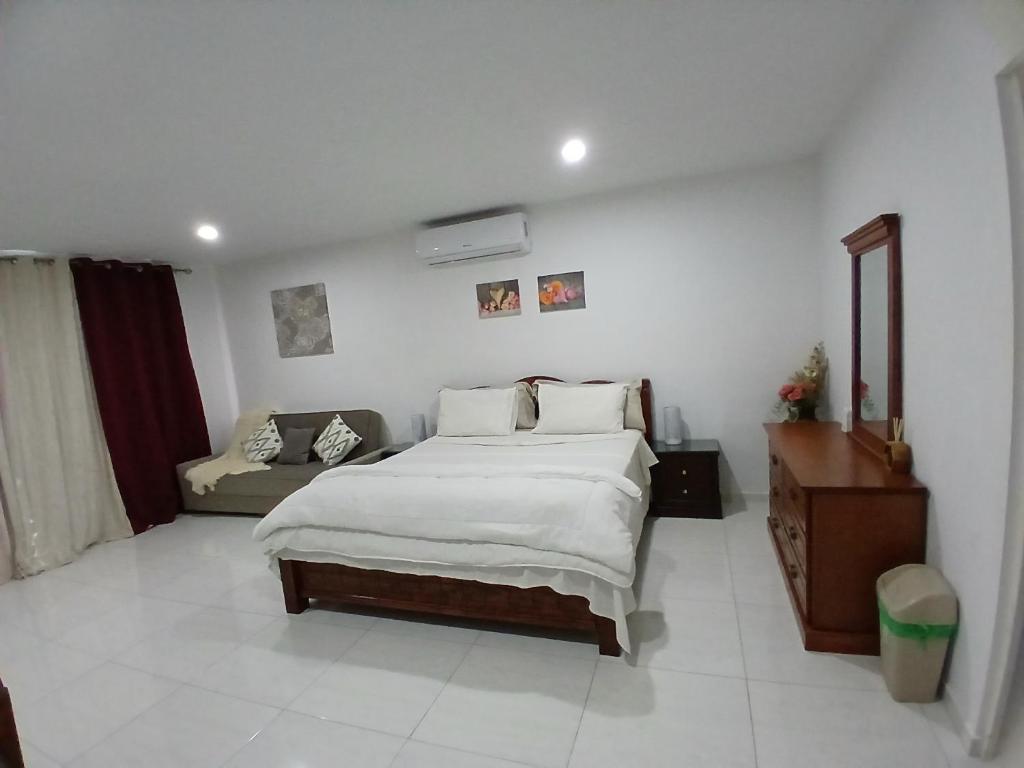 a bedroom with a large bed and a couch in it at Cayenas Apartament in Willemstad