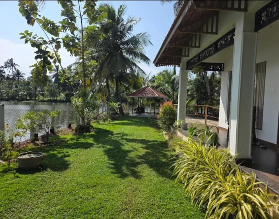 a yard outside of a house with a grassy yard at Riverview villa in Alleppey
