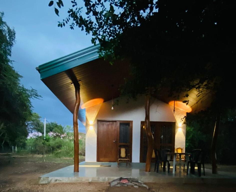 a house with a table and chairs in front of it at Villu Trails Wilpattu in Wilpattu