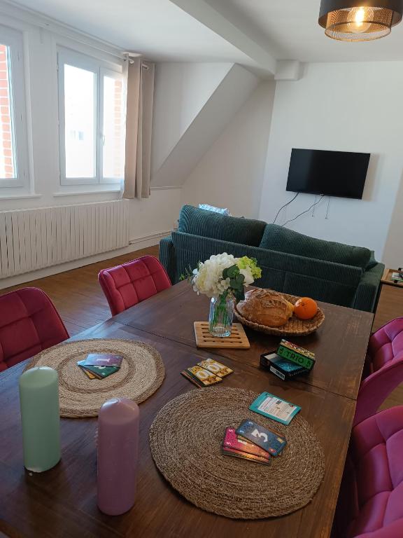 a living room with a table and a couch at Le Refuge de la Tour in Calais