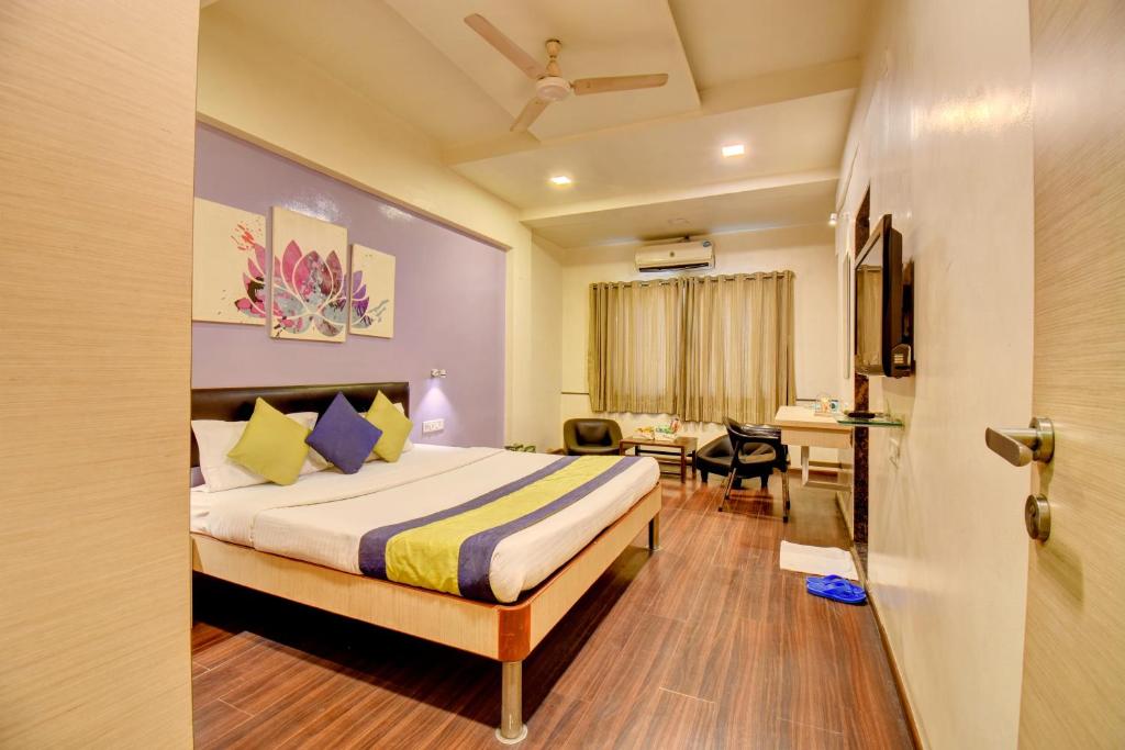 ein Hotelzimmer mit Bett und Schreibtisch in der Unterkunft MY Bizz Hotel Sapna in Pune