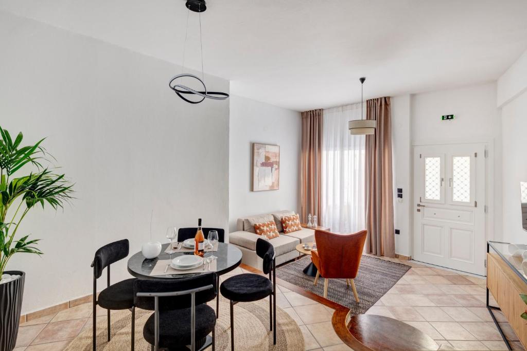 a living room with a table and chairs and a couch at VERSA by Apiro Syros in Ermoupoli