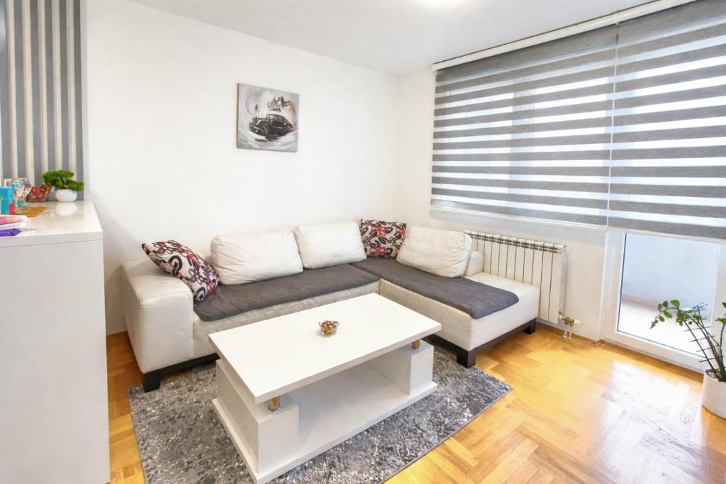 a living room with a couch and a table at Apartman Dreams Lukavica in Lukavica
