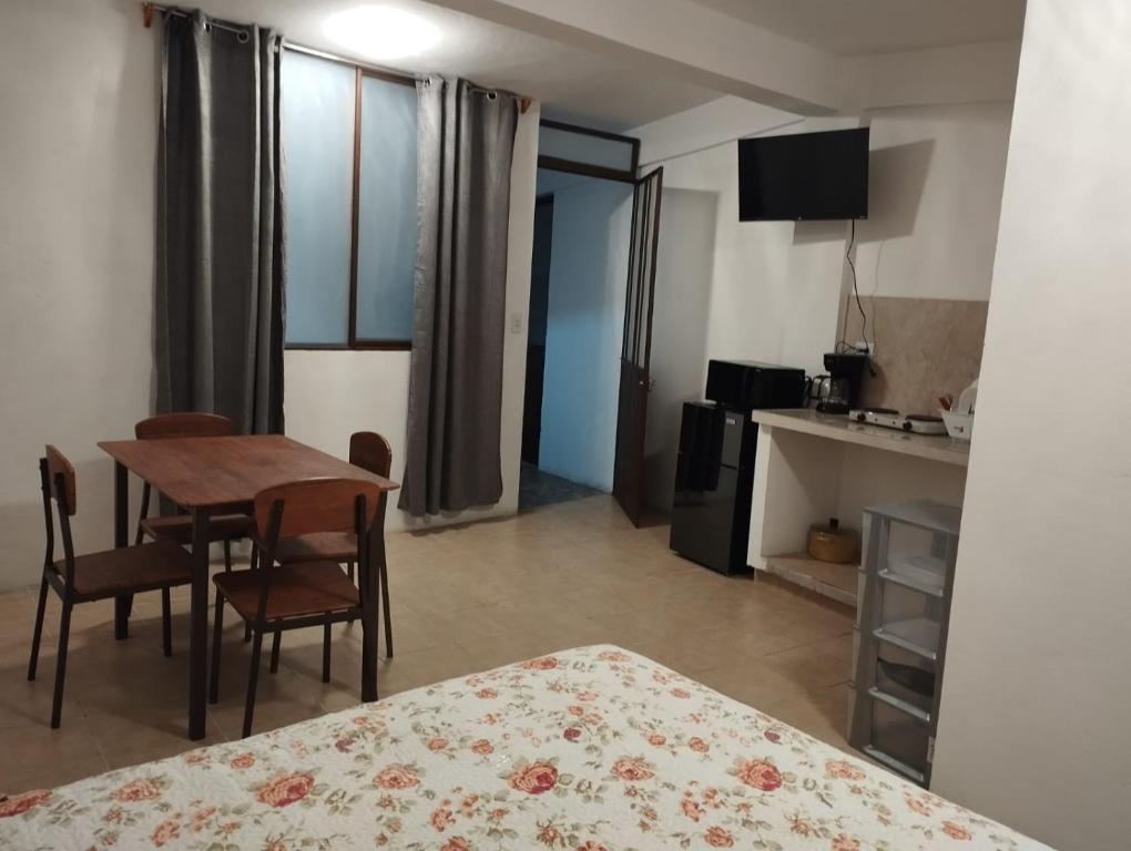 a room with a table and chairs and a kitchen at Lofts en el Corazon de Coatepec Veracruz in Coatepec