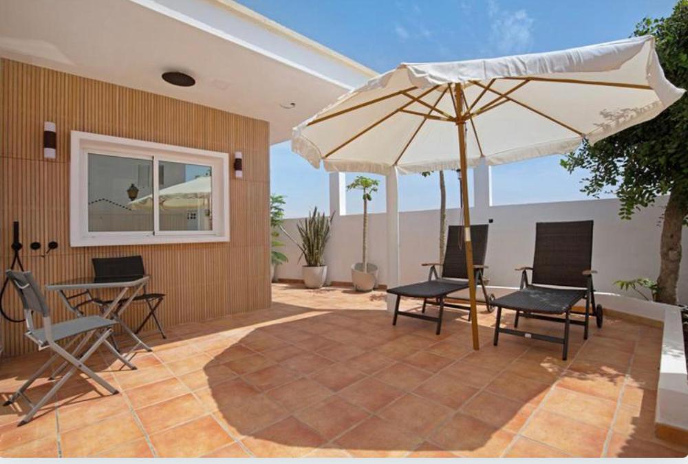 a patio with a table and an umbrella at Las Arenas in Costa Calma