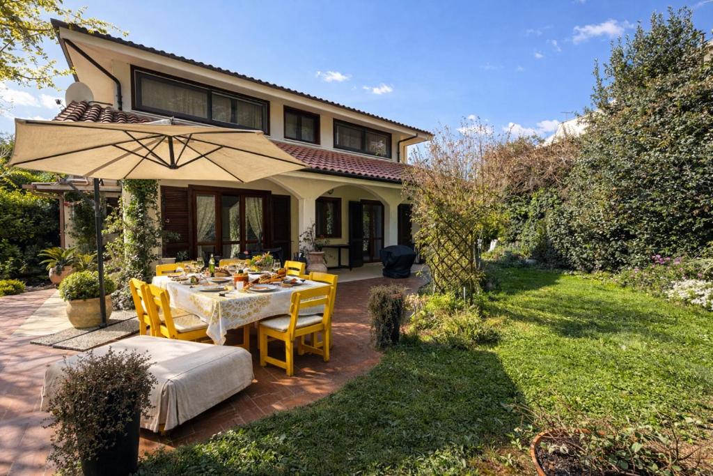 a patio with a table and chairs and an umbrella at Casa di Rita in Morlupo
