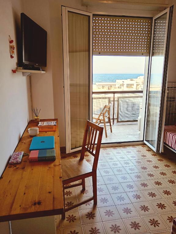a living room with a table and a view of the ocean at Suite Fronte Mare Senigallia- Terrazza Esclusiva sulla Spiaggia in Senigallia