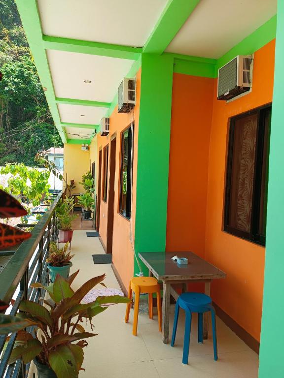 a building with colorful walls and a table and chairs at Aquing's Place in El Nido