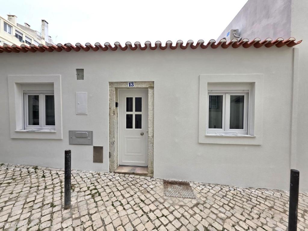 a white house with a white door and two windows at Casinhas da Ajuda nº13 in Lisbon