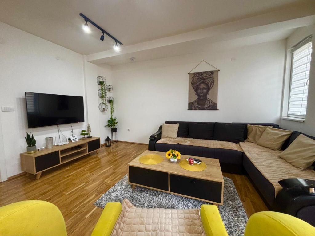 a living room with a couch and a flat screen tv at N&M Apartment in Pirot