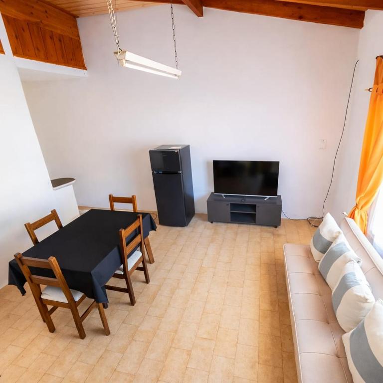 a living room with a black table and a tv at Alquiler por Día SyA Cipolletti in Cipolletti
