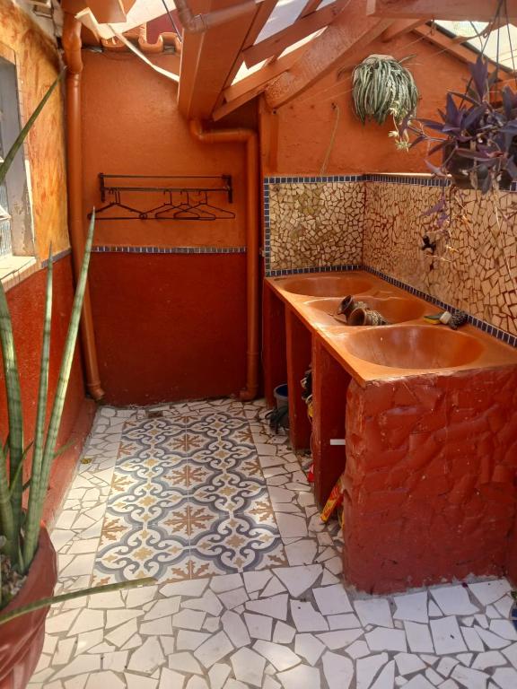 a bathroom with a sink and a tile floor at Casa estilo colonial próximo Paço Municipal in Goiânia