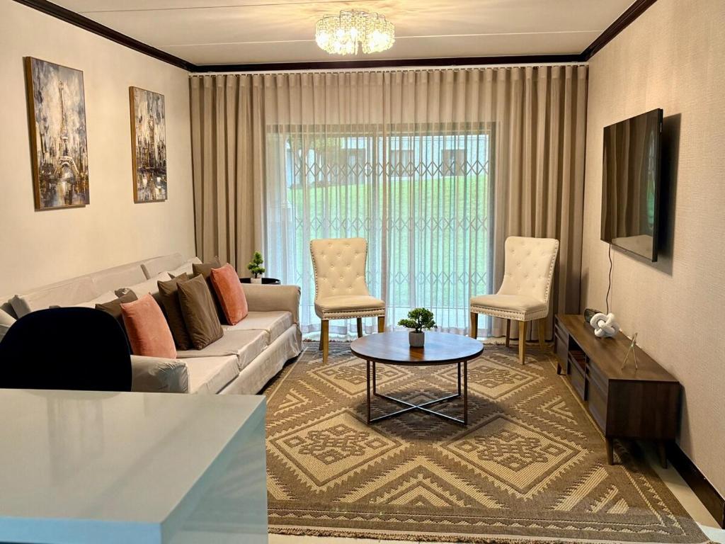 a living room with a couch and a table at The Calm Corner in Trevallyn