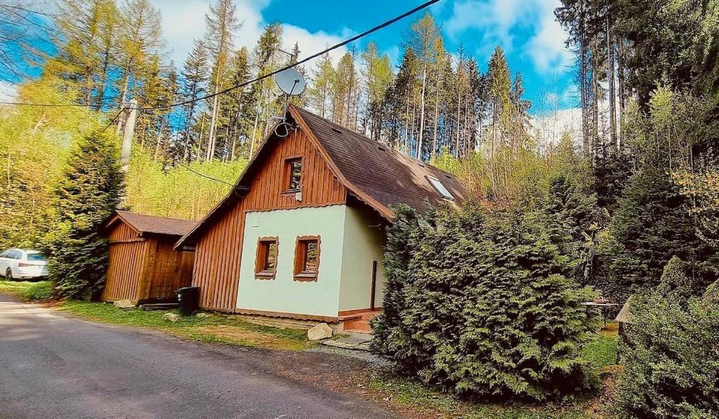 a small wooden house on the side of a road at Chalupa Špičák in Jablonec nad Nisou
