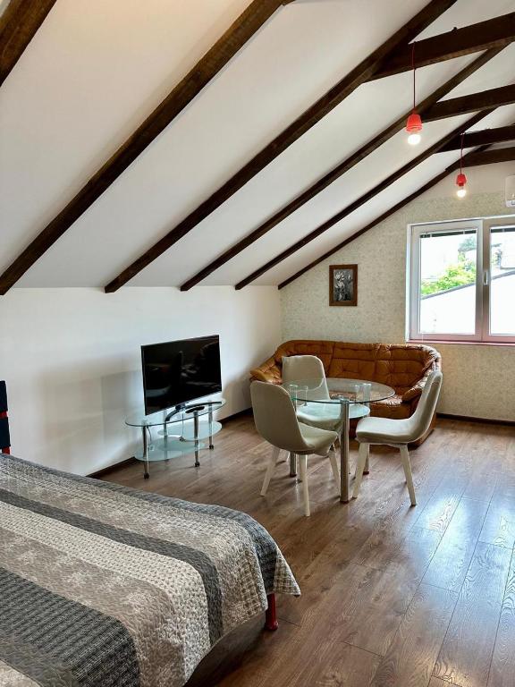 a attic room with a bed and a table and a couch at Loft Studio in Igalo