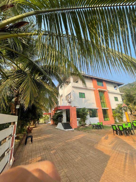 a view of a building with a palm tree at Blue Diamond Dapoli in Murūd