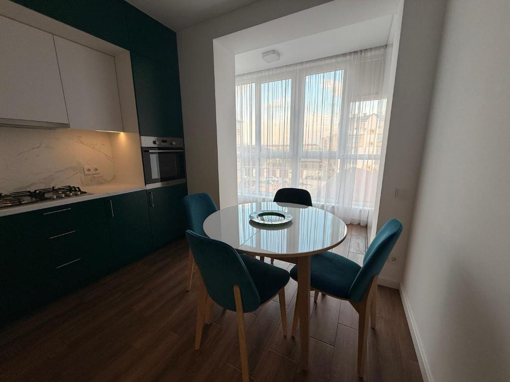 a kitchen with a table and chairs in a room at GS Green Apartment in Starokostyantyniv