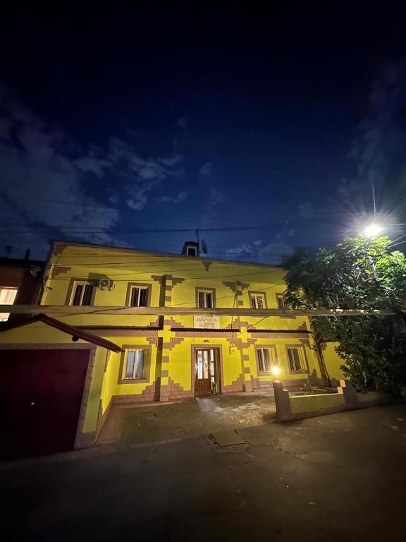 a yellow building at night with a light on it at Li Yes Yerevan hotel in Yerevan