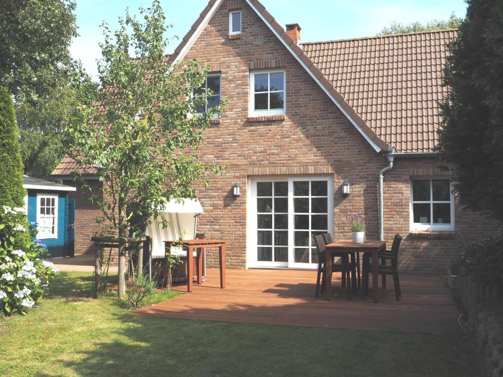 a patio with a table and chairs in front of a house at Ferienhaus Leegwater in Munkmarsch