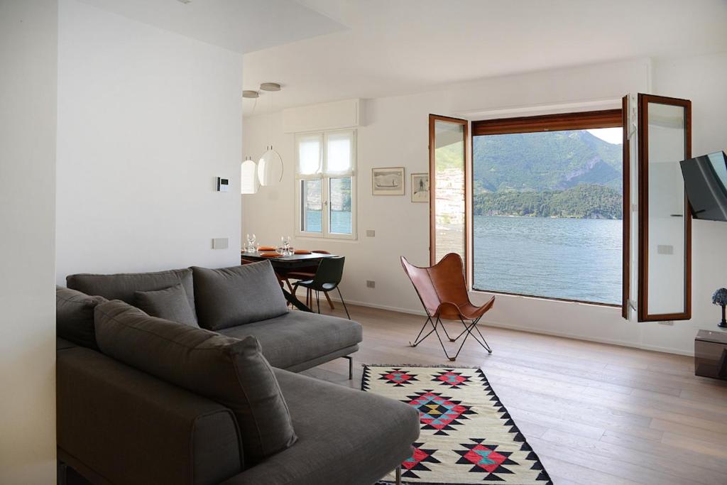 a living room with a couch and a table and a window at Rhapsody on the Lake in Lezzeno