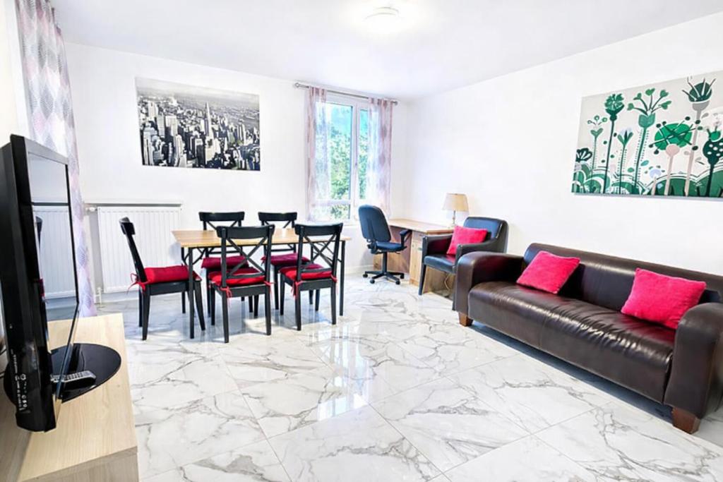 a living room with a couch and a table and chairs at Paris & Disney - 5 mins from Train Station - Champs Harmony in Champs-sur-Marne