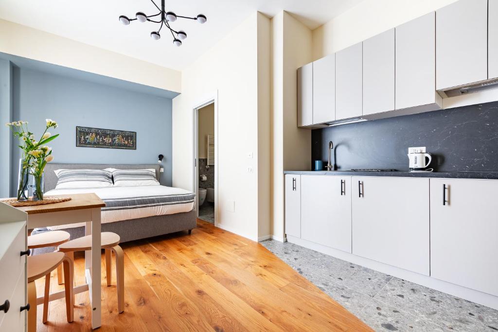 a kitchen with white cabinets and a bed in a room at Piccinni 133 in Bari