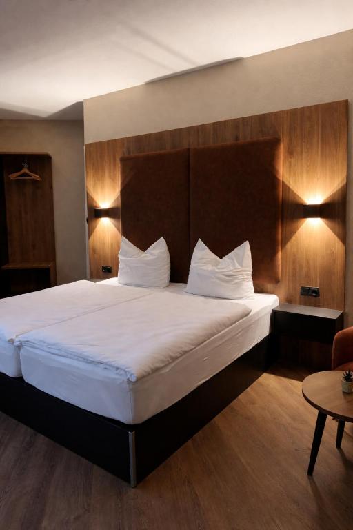 a bedroom with a large bed with a wooden headboard at Hotel und Restaurant Hohe Schule in Herborn