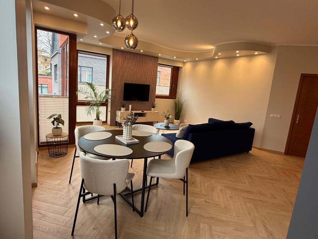 a living room with a table and chairs and a couch at Vallikraavi Old Town Apartment in Tartu