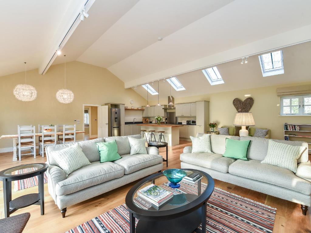 a living room with a couch and a table at Beaufort Dairy in Pulborough