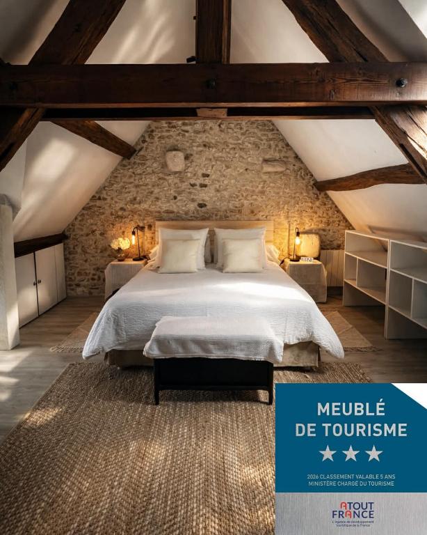 a bedroom with a large bed in an attic at Le Cottage des Chalands - classé 3 étoiles in Saint-Georges-sur-Cher