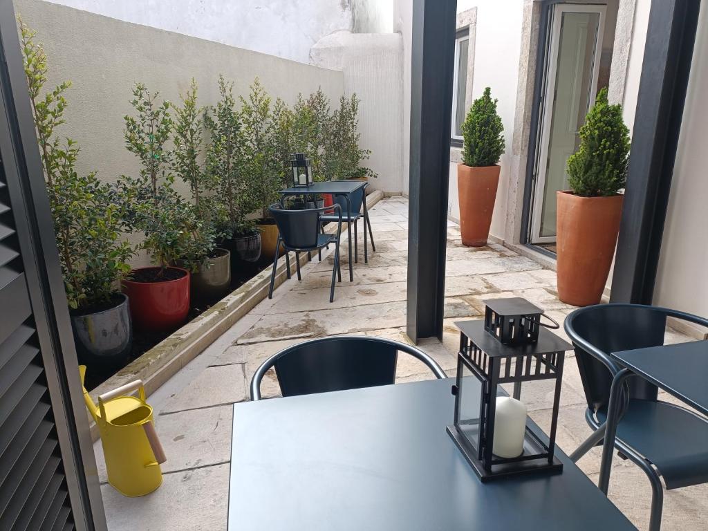 a patio with tables and chairs and potted plants at Correio Velho Hotel in Lisbon