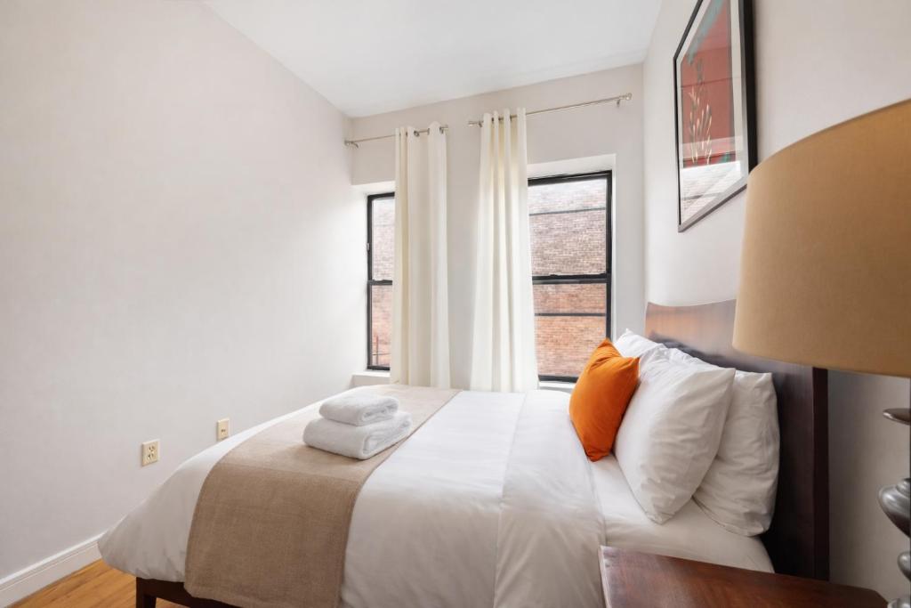 a bedroom with a bed with two towels on it at Plush & Spacious 2-Bedroom in NYC in New York