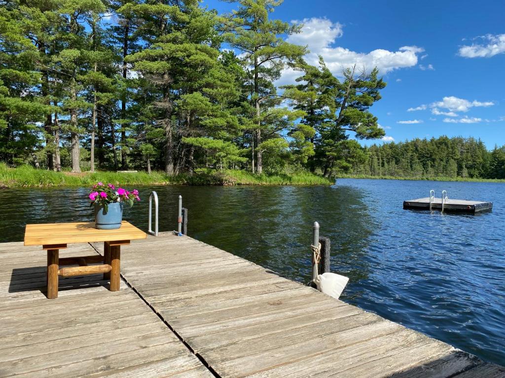 a wooden dock with a table and flowers on it at Loonsight in Minocqua