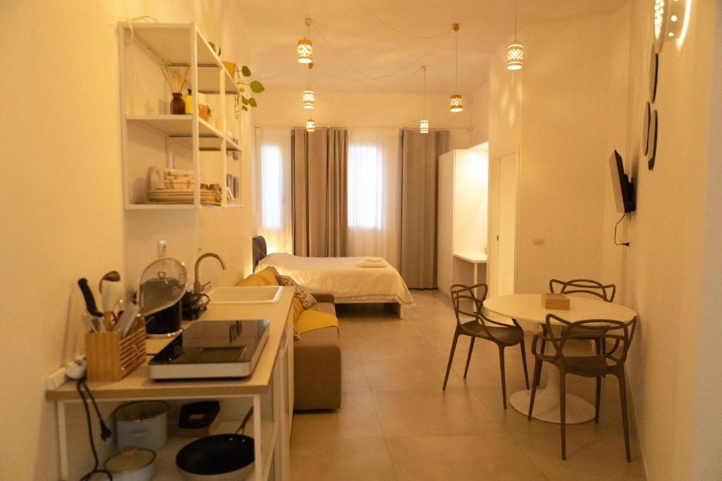a living room with a kitchen and a bedroom at Idumea Rooms in Lecce