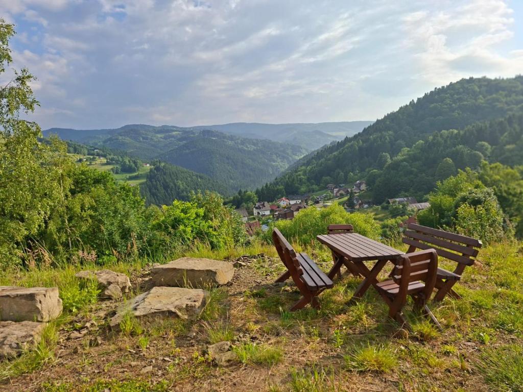 a wooden table and benches sitting on top of a hill at Camping Obłazek in Piwniczna-Zdrój