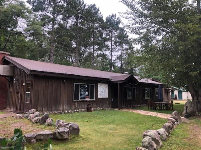 a small house with a yard with rocks in front of it at Gresham Shores - Lil' Sunfish - PET FRIENDLY in Arbor Vitae