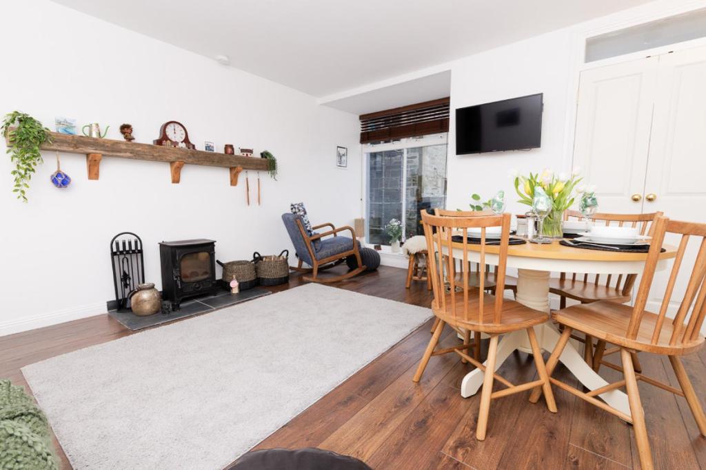 a living room with a table and chairs and a fireplace at Bains Closs, Shetland Islands in Lerwick