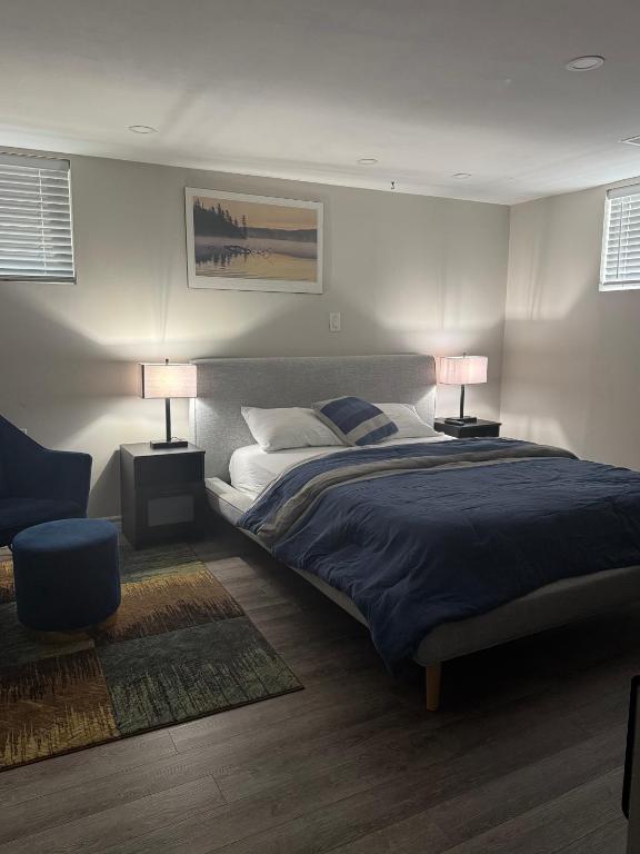 a bedroom with a bed and two lamps and a chair at Joshie Stays in Hamilton