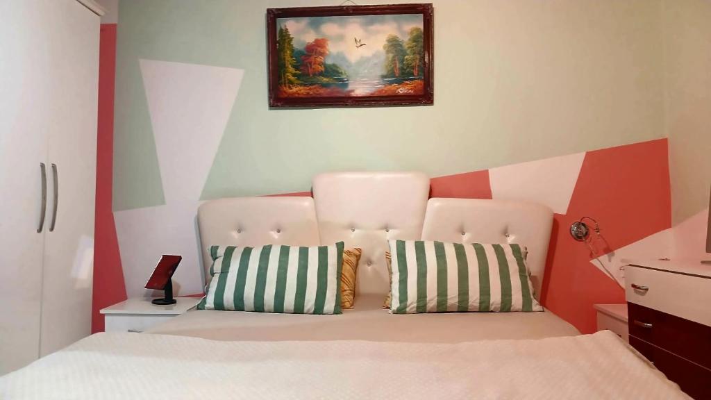 a bedroom with a bed and a painting on the wall at Stairway to heaven in Shkodër
