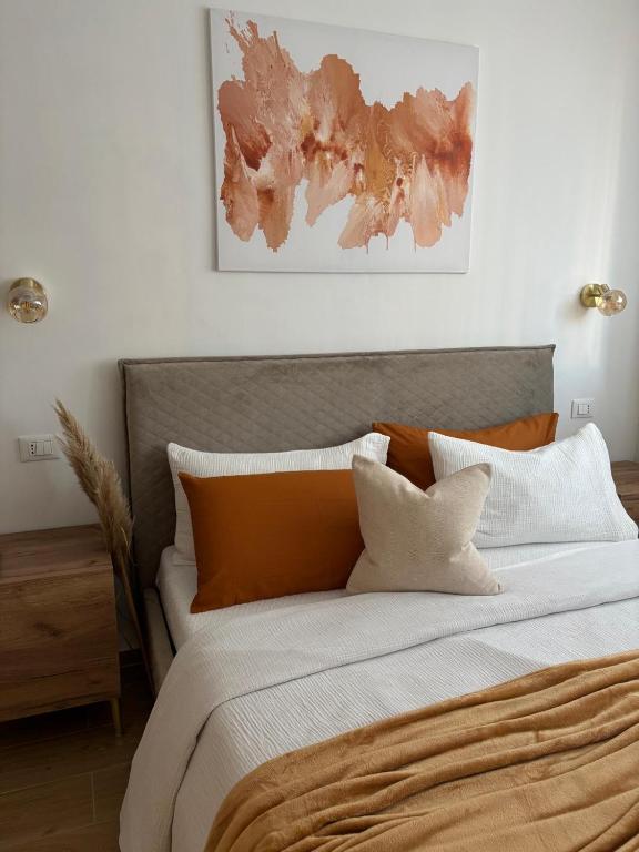 a bedroom with a large bed with orange and white pillows at Lo Spaho Suite Florence in Florence